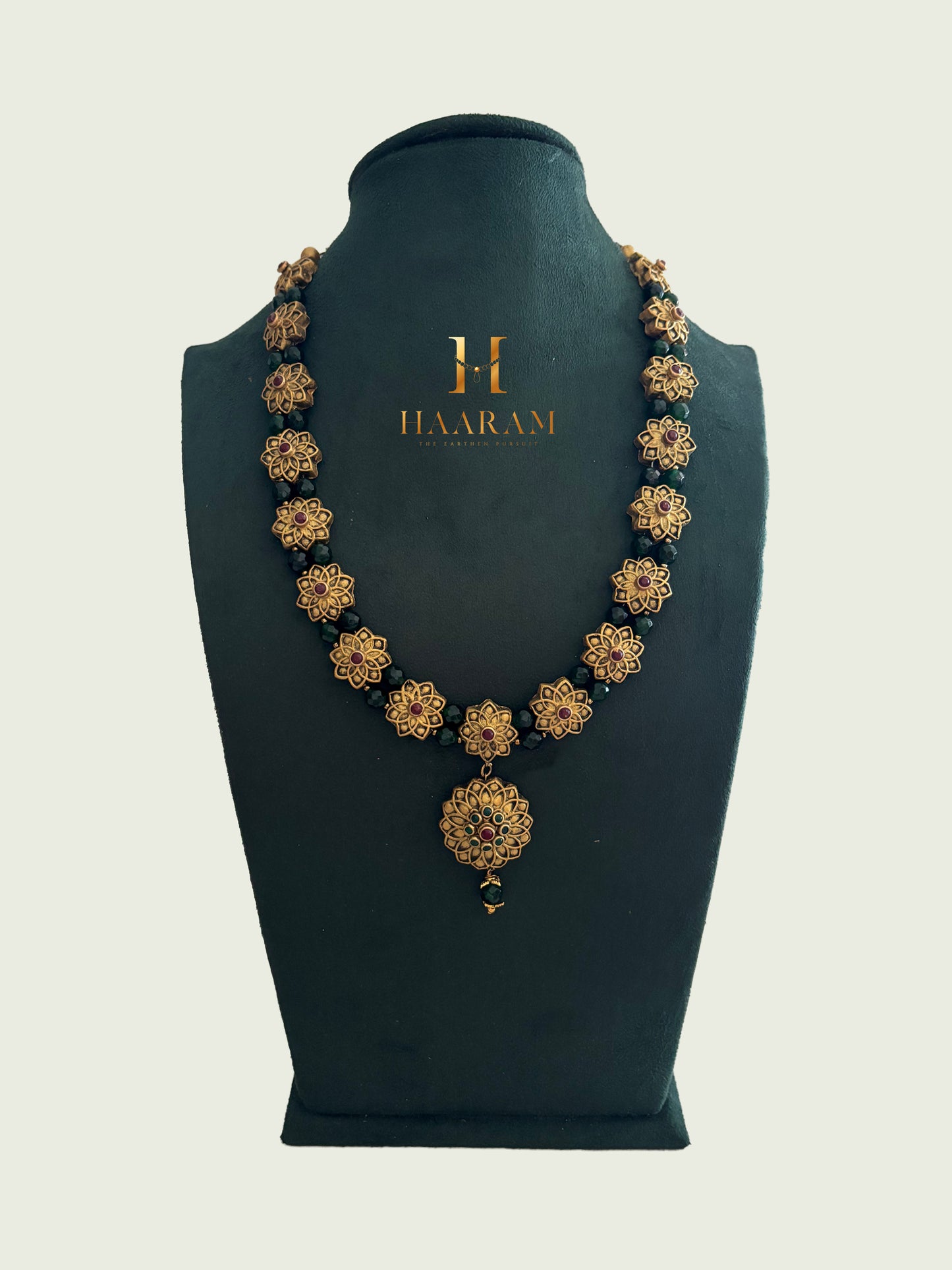 Floral motif terracotta necklace with round pendant in antique gold tone by Haarambyyashh.