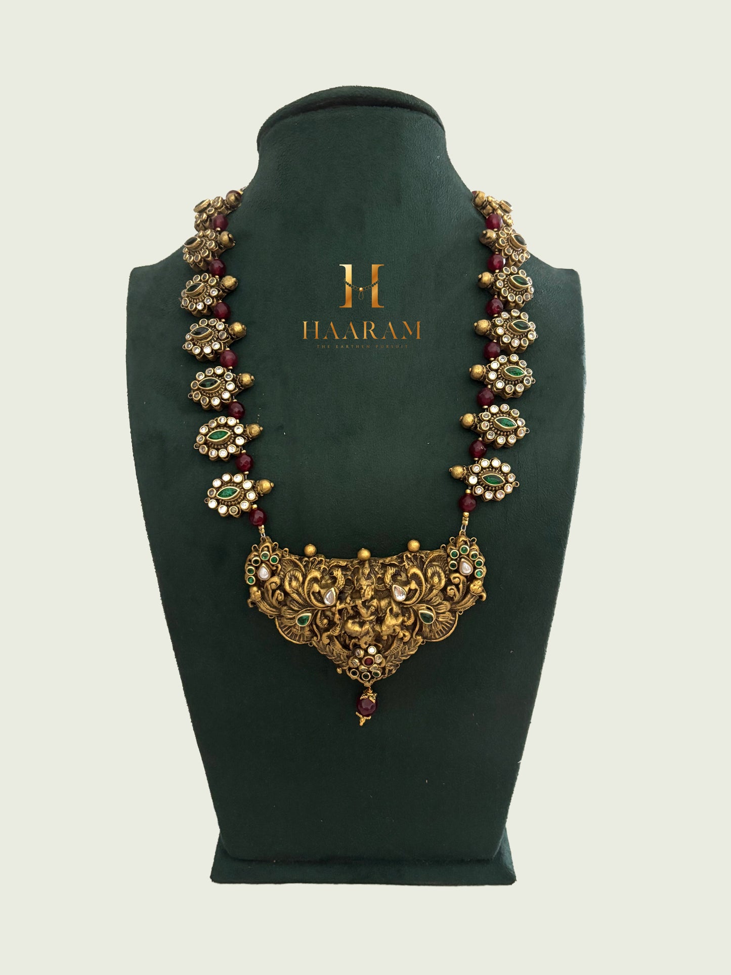 Handcrafted terracotta necklace with temple-style carvings, green stones, ruby bead-work, and antique gold finish by Haarambyyashh.