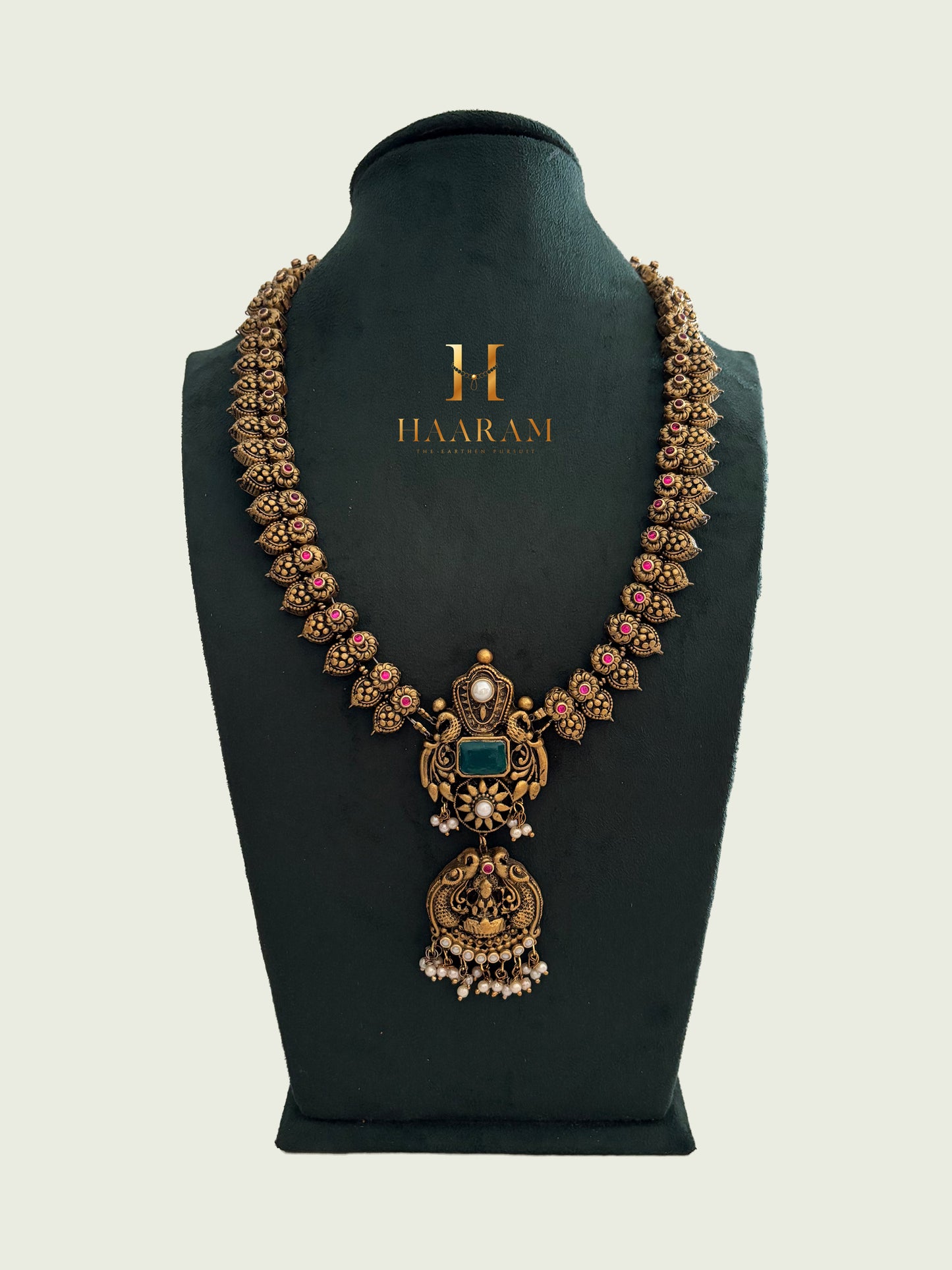 Antique terracotta necklace with triangular floral links, green stone centerpiece, and ornate pendant from Haarambyyashh.