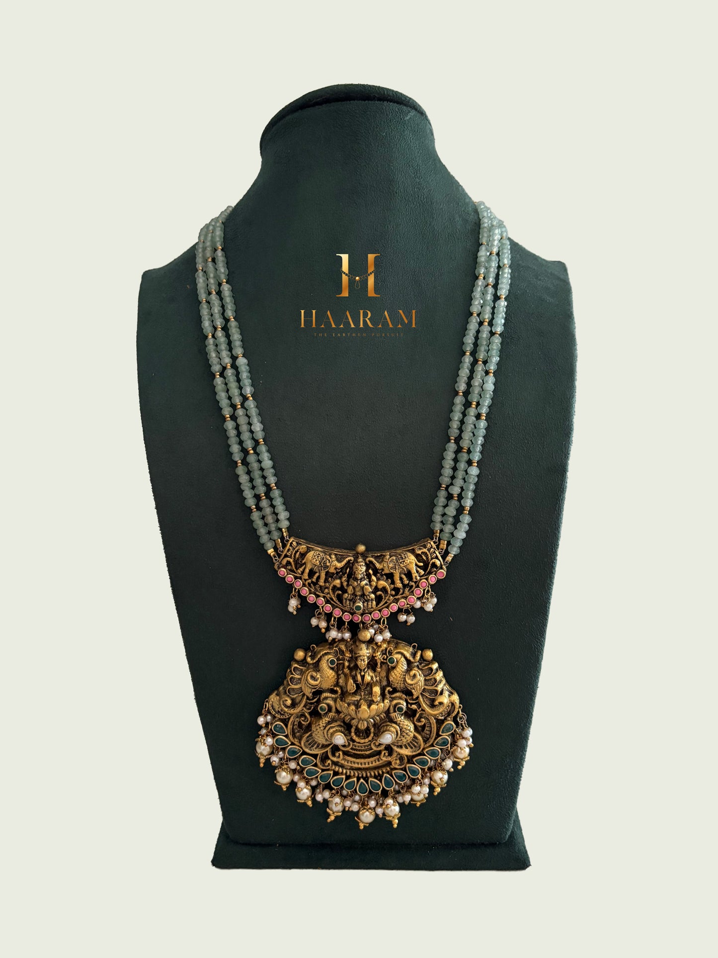 Terracotta long necklace with green bead strands and layered antique gold pendant from Haarambyyashh.