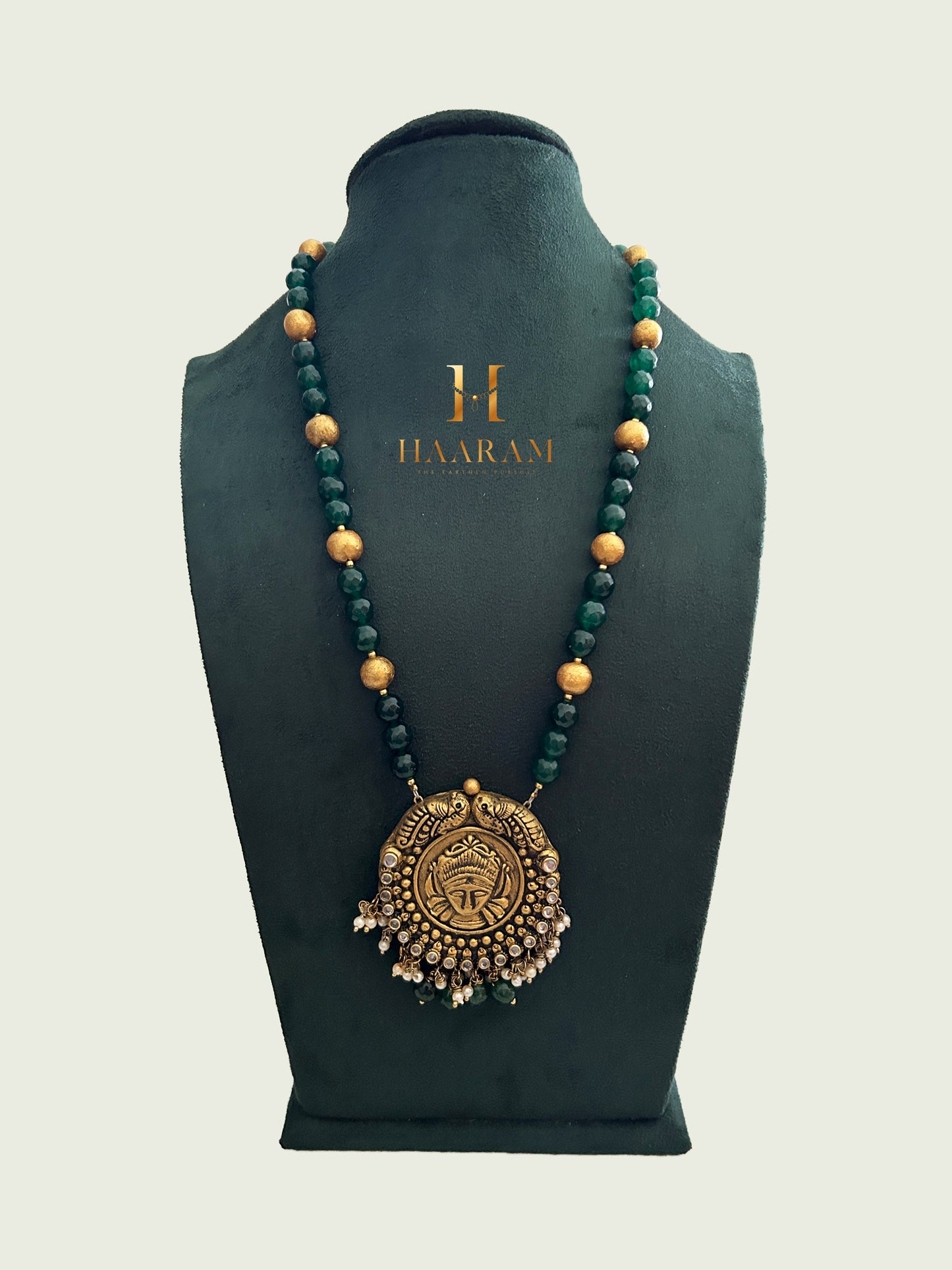 Terracotta necklace with an antique gold-finish peacock design pendant and green and gold beads from Haarambyyashh