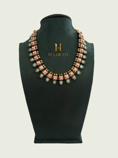 Pink terracotta necklace with teardrop accents and gold detailing by Haarambyyashh.