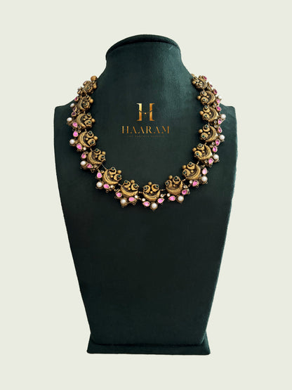 Pink-accented terracotta necklace with floral detailing and antique finish by Haarambyyashh.