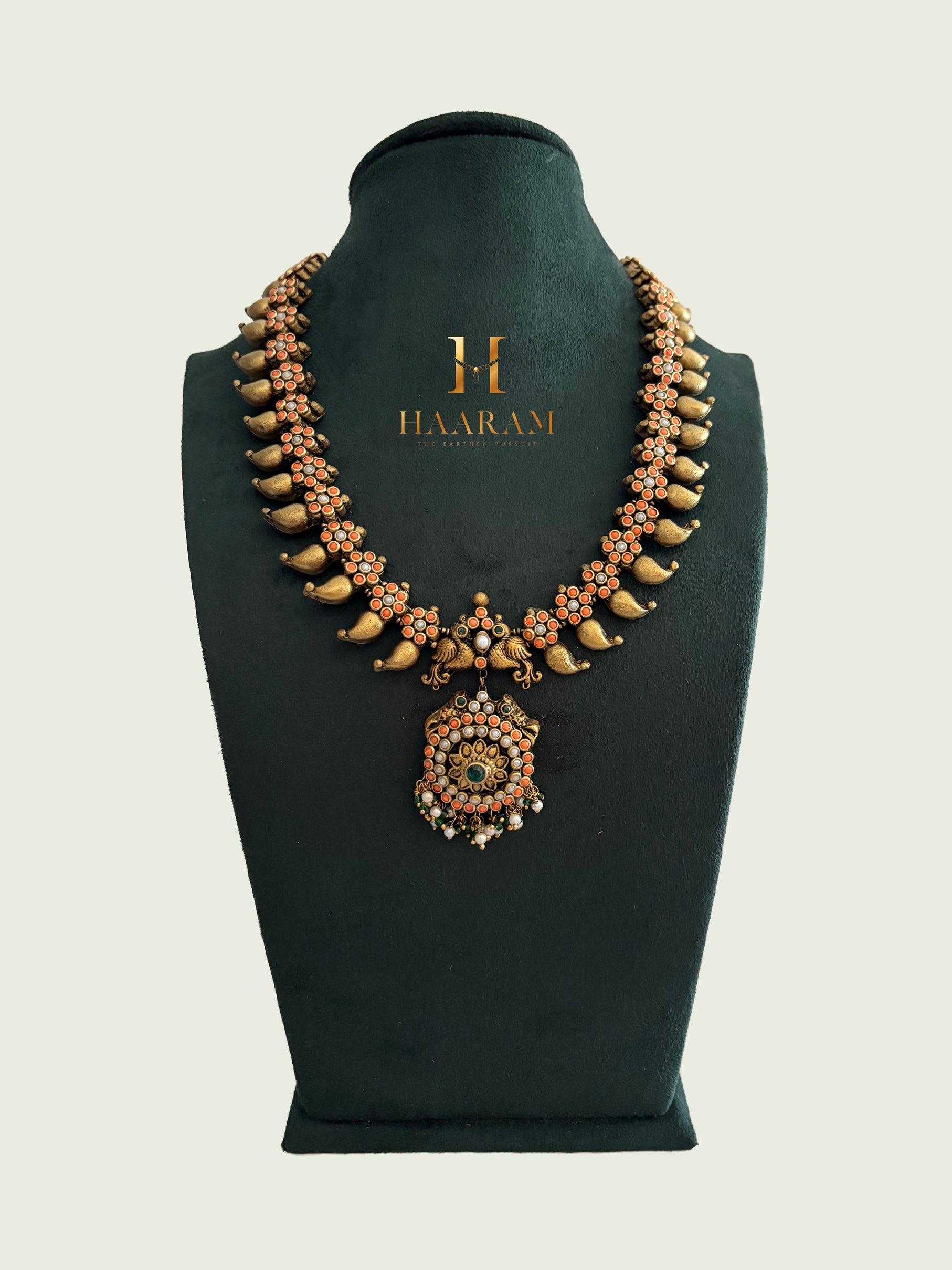 Terracotta necklace with gold tusk design, floral beads, and round pendant from Haarambyyashh.
