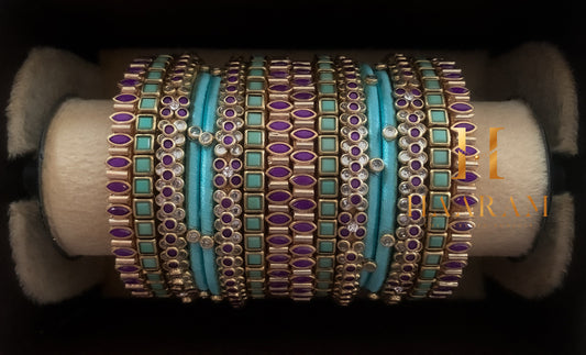 Turquoise and gold silk thread bangles with stone accents displayed on a wooden stand.