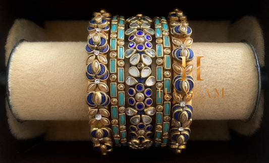 Purple and gold silk thread bangles with sparkling stones displayed on a wooden stand.