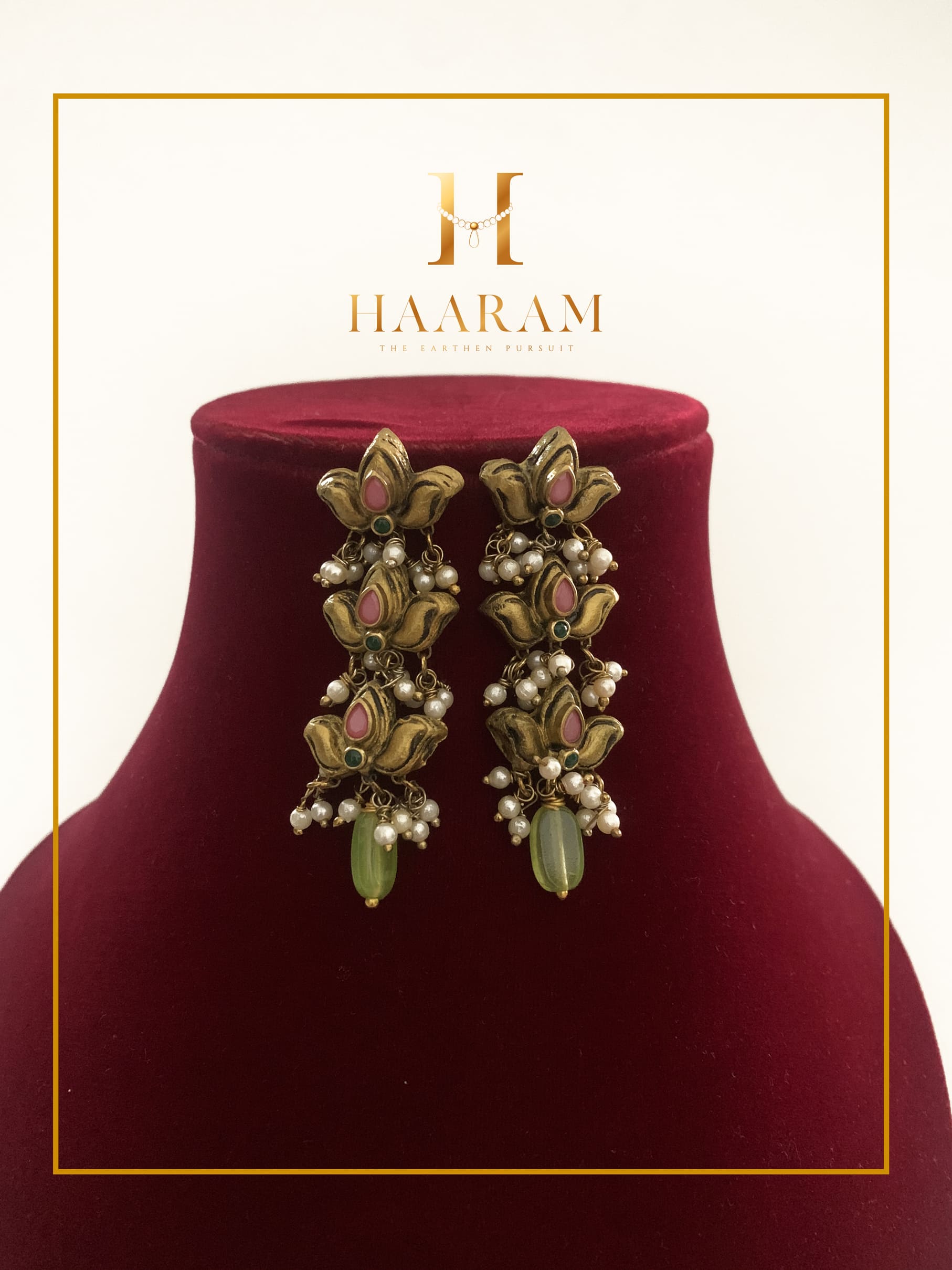 Handcrafted terracotta earrings by HaarambyYashh featuring floral motifs with pink and green accents, adorned with pearl clusters.