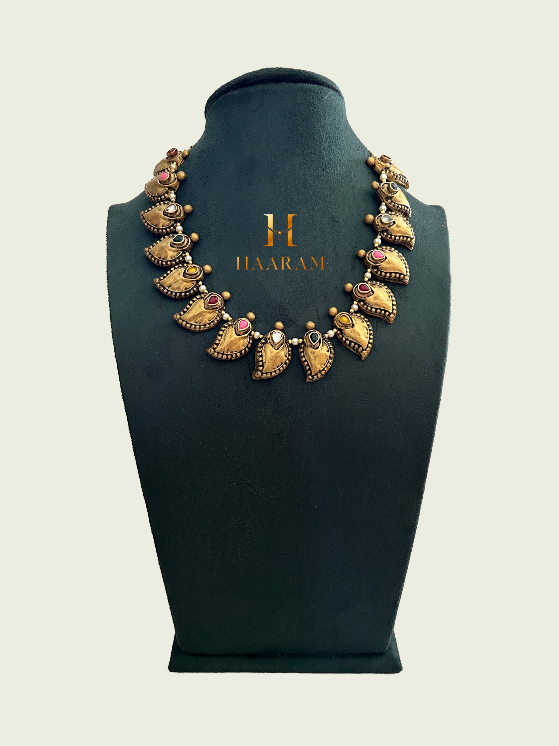 Handcrafted terracotta necklace with gold-tone paisley-shaped pendants, adorned with colored stones from Haarambyyashh. 