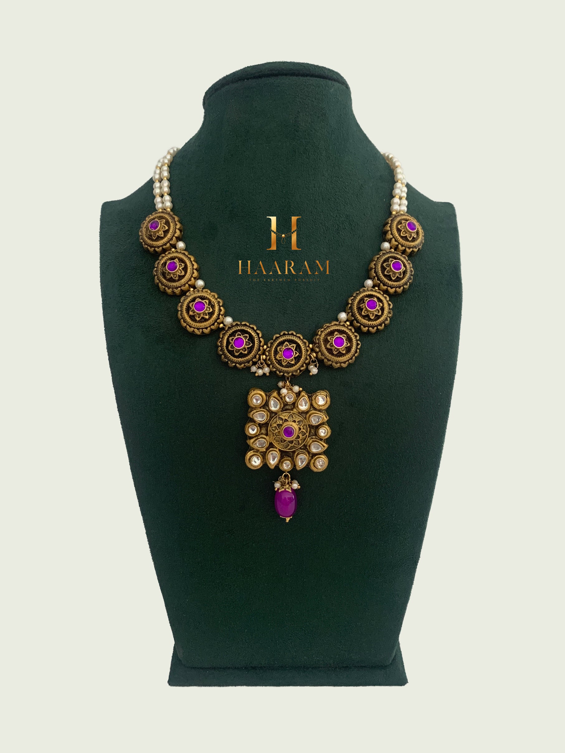 Terracotta necklace with round antique gold-finish pendants featuring purple stones and a central ornate pendant with pearls from Haarambyyash